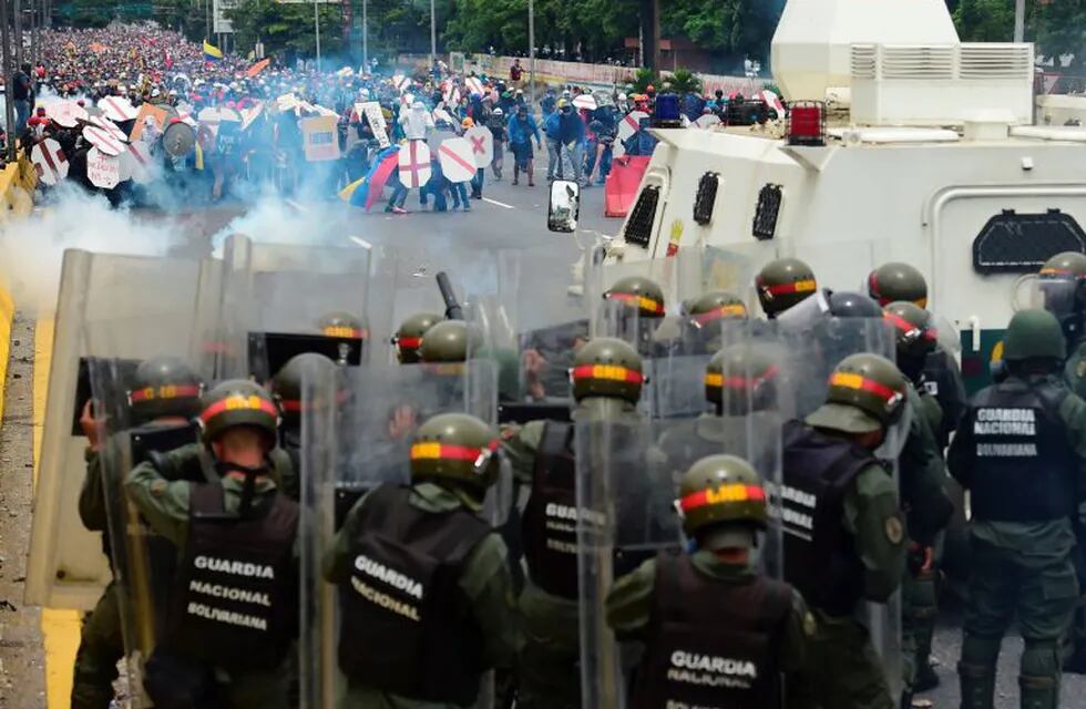 Riot police and demonstrators clash during a protest against Venezuelan President Nicolas Maduro, in Caracas on May 3, 2017.nVenezuela's angry opposition rallied Wednesday vowing huge street protests against President Nicolas Maduro's plan to rewrite the constitution and accusing him of dodging elections to cling to power despite deadly unrest. / AFP PHOTO / RONALDO SCHEMIDT