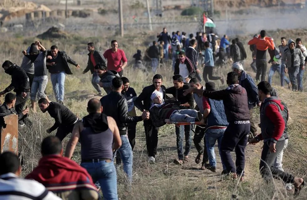 East Gaza (---), 08/12/2017.- Palestinian protesters carry a wounded young during a protest against US President decision to recognize Jerusalem as the capital of Israel, during clashes along the border between Israel and east Gaza, 08 December 2017. Palestinians announced general strike and a rage day to protest against US President Donald J. Trump declaration recognizing Jerusalem as the capital of the Israel. US President Trump on 06 December announced he is recognising Jerusalem as the Israel capital and will relocate the US embassy from Tel Aviv to Jerusalem. (Protestas, Jerusalén, Estados Unidos) EFE/EPA/MOHAMMED SABER