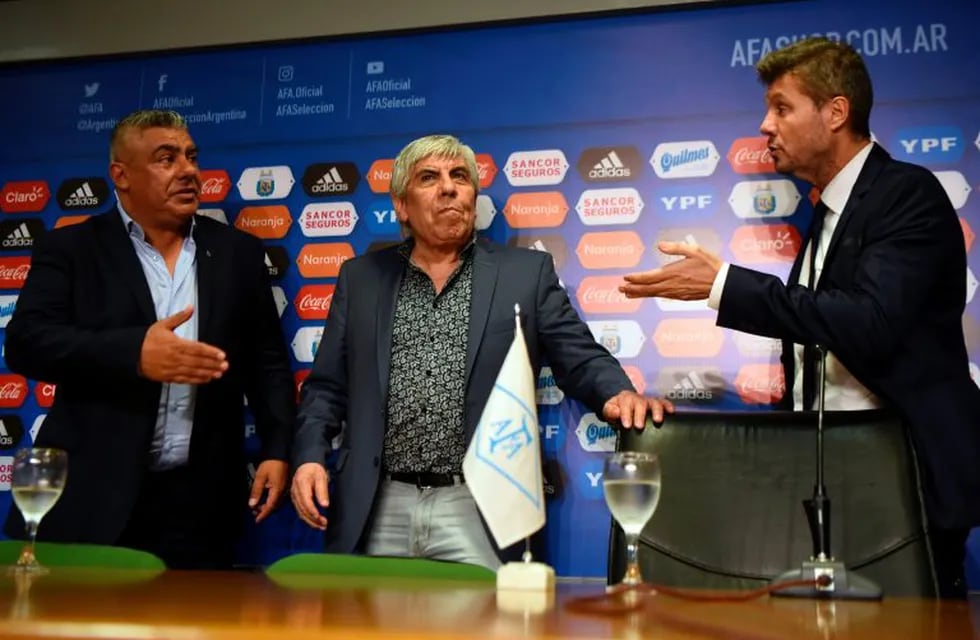 Newly elected President of Argentina's Football Association (AFA), Claudio Tapia (L), Independiente's president Hugo Moyano (C) and the president of the National Selections Committee, Marcelo Tinelli, leave after a press conference in Ezeiza, Buenos Aires