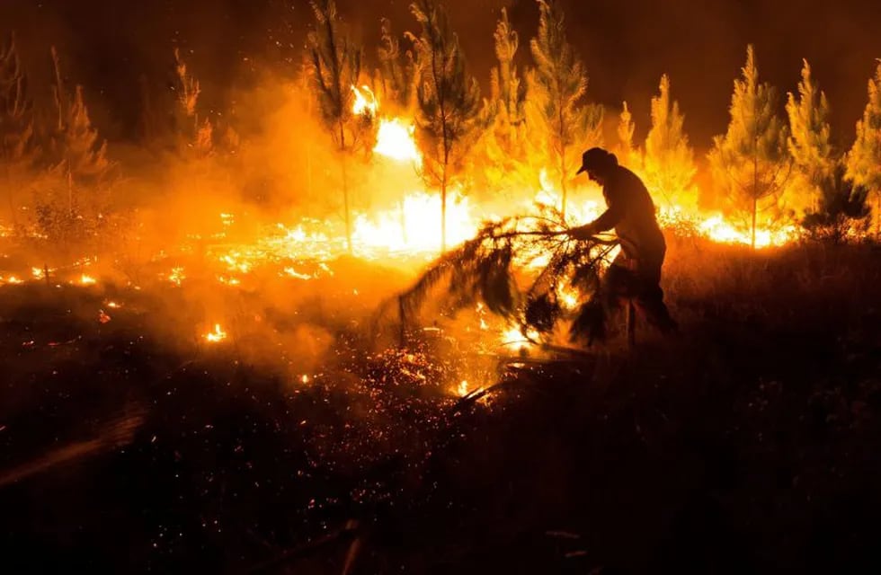 AME3902. NACIMIENTO (CHILE), 15/02/2019.- Bomberos trabajan para extinguir un incendio en la madrugada de este viernes, en la comuna de Nacimiento, en la región del Bíobio (Chile). Un total de 31 incendios forestales se mantienen activos en diversas regiones del centro y sur de Chile este viernes, mientras otros 50 están bajo control y cuatro fueron declarados extinguidos, para un total de 85, informaron las autoridades. EFE/ Camilo Tapia
