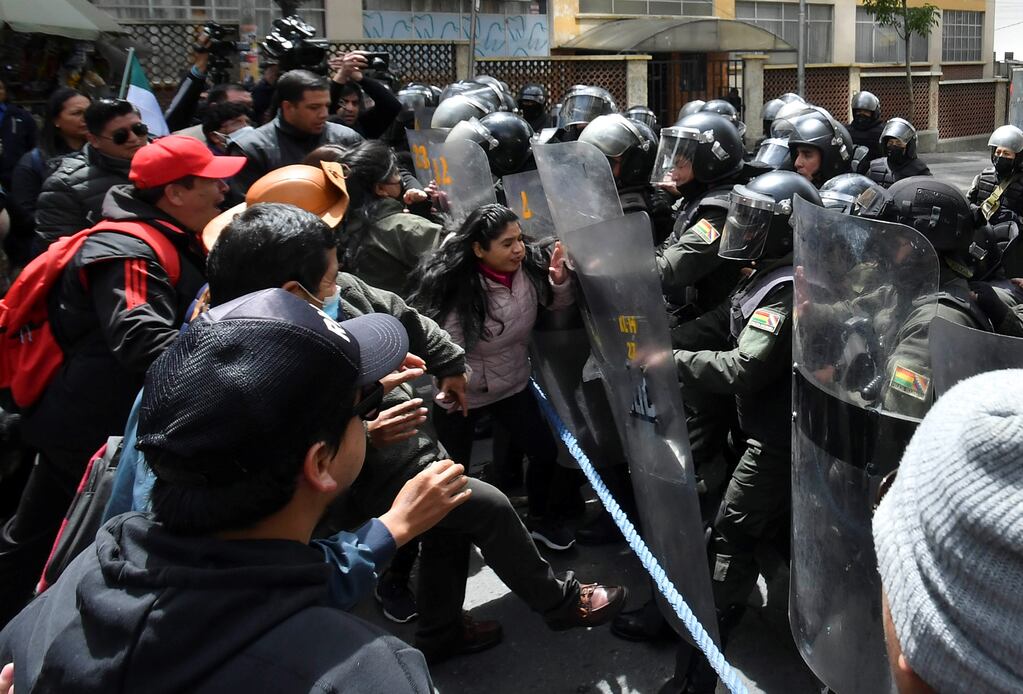 Maestros de zonas urbanas bolivianas se enfrentan con policías durante una marcha por diversas reivindicaciones laborales, el jueves en La Paz (Bolivia).