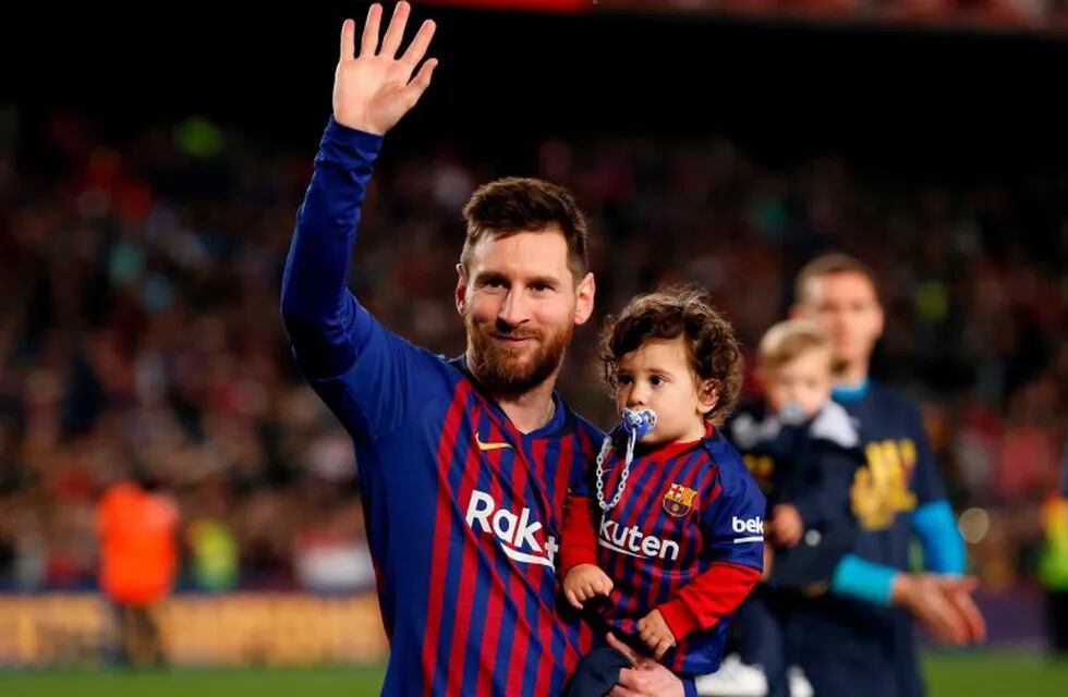 Barcelona's Argentinian forward Lionel Messi holds his son Ciro as he celebrates after Barcelona won their 26th league title at the end of the Spanish League football match between Barcelona and Levante at the Camp Nou stadium in Barcelona on April 27, 2019. (Photo by PAU BARRENA / AFP)