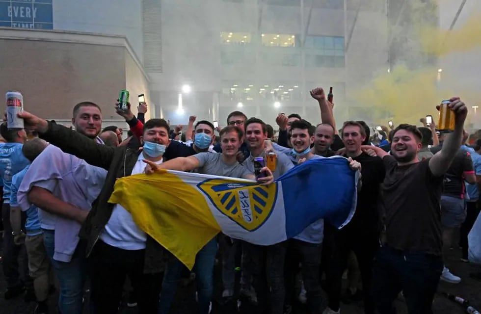 Leeds United supporters gather outside their Elland Road ground to celebrate the club's return to the Premier League after a gap of 16 years, in Leeds, northern England on July 17, 2020. - Leeds United were promoted to the Premier League on Friday after West Bromwich Albion's 2-1 defeat at Huddersfield ensured the Championship leaders will end their 16-year exile from the top-flight. (Photo by Paul ELLIS / AFP)