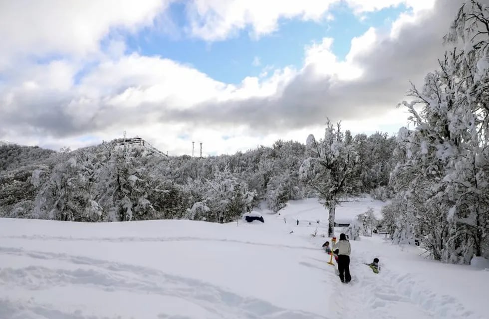 Kids enjoy playing with snow on the Otto hill during the lockdown imposed by the government against the spread of the new coronavirus, COVID-19, in Bariloche, Rio Negro, Argentina, on June 24, 2020. - Though the city of Bariloche is already covered with snow, this year there will be no avalanche of visitors in this popular tourist destination due to the coronavirus pandemic. (Photo by FRANCISCO RAMOS MEJIA / AFP)