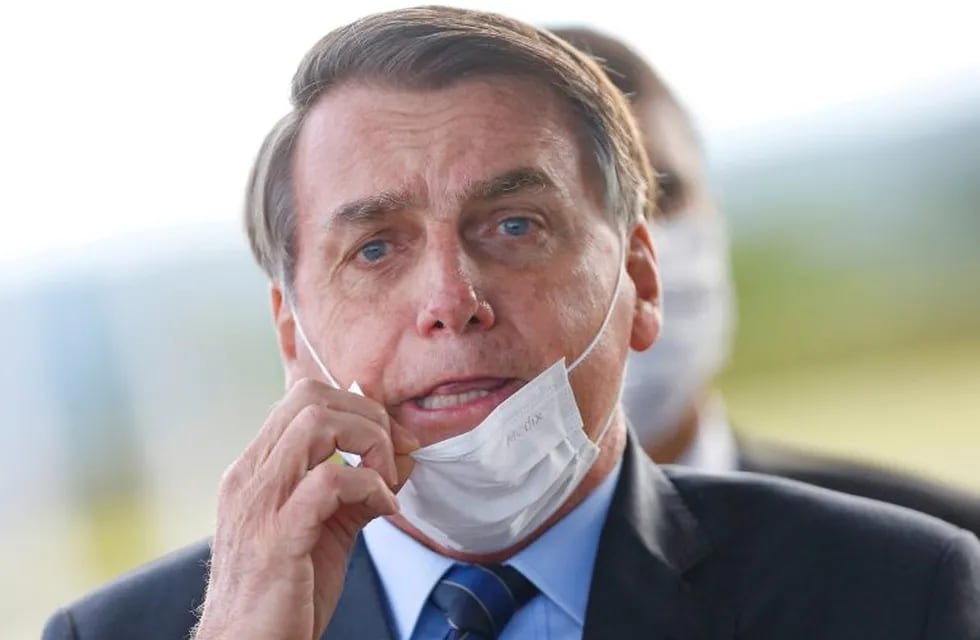 FILE PHOTO: Brazil's President Jair Bolsonaro adjusts his mask as he leaves Alvorada Palace, amid the coronavirus disease (COVID-19) outbreak in Brasilia, Brazil May 13, 2020. REUTERS/Adriano Machado/File Photo