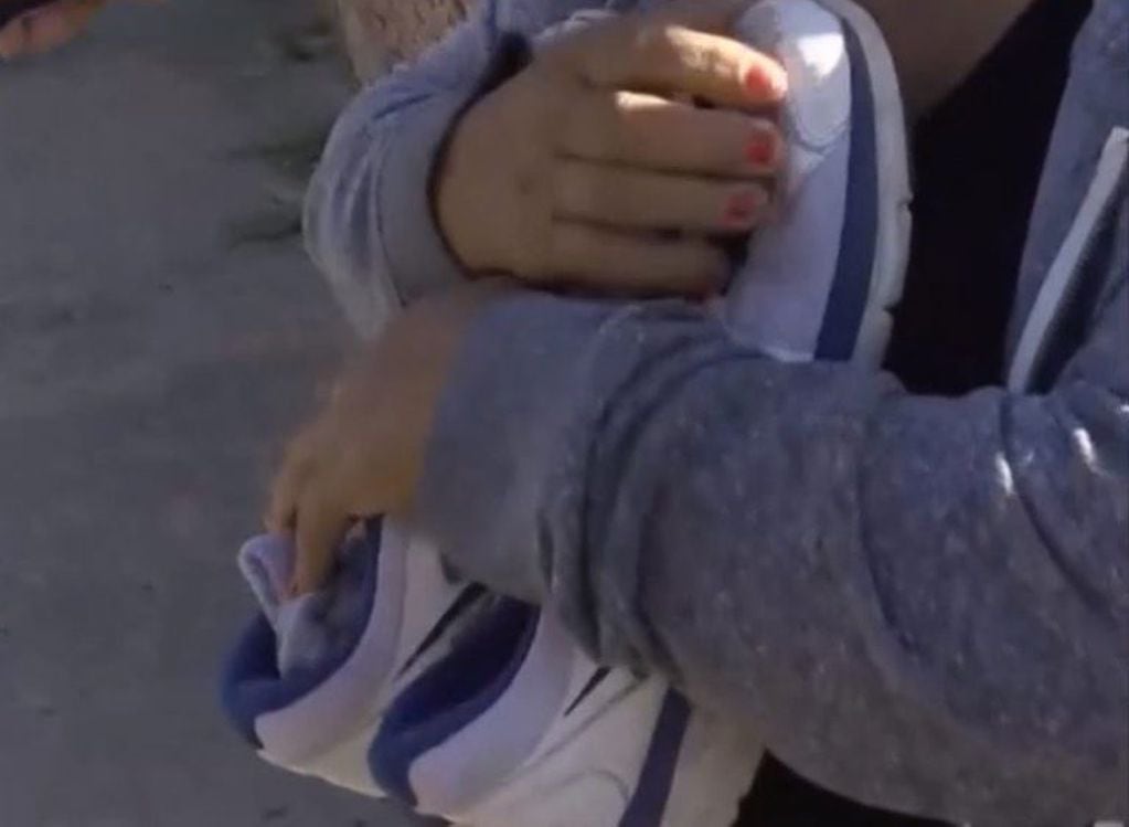 Mónica Cabrera, la madre de Martín Sebastián Berton, aferrada a las zapatillas de su hijo asesinado en Villa Gobernador Gálvez. (Captura de pantalla)