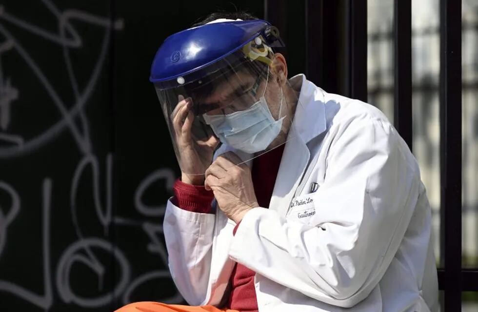 A doctor speaks on a mobile phone as health workers demand better working conditions and pay homage to nurse Grover Licona, who died from COVID-19, outside the Carlos G. Durand hospital in Buenos Aires, on August 18, 2020, amid the new coronavirus pandemic. (Photo by JUAN MABROMATA / AFP)