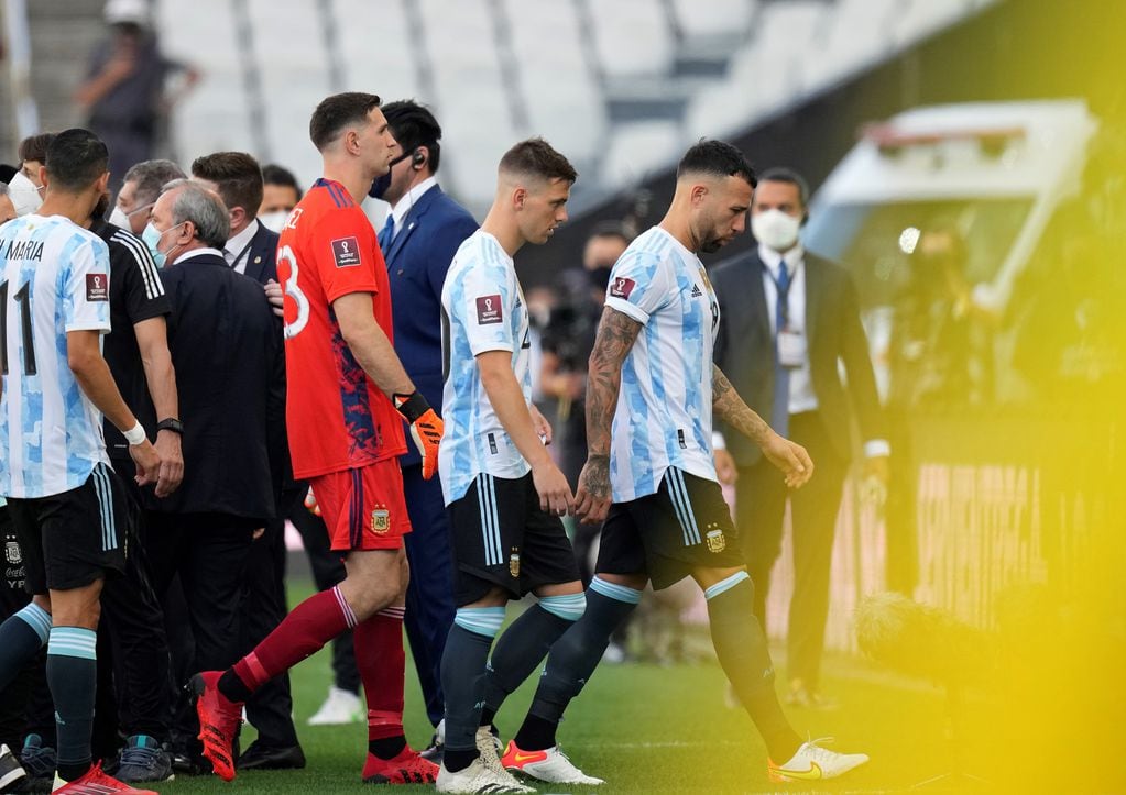 Los jugadores argentinos se retiran hacia el vestuario tras la suspensión del partido.