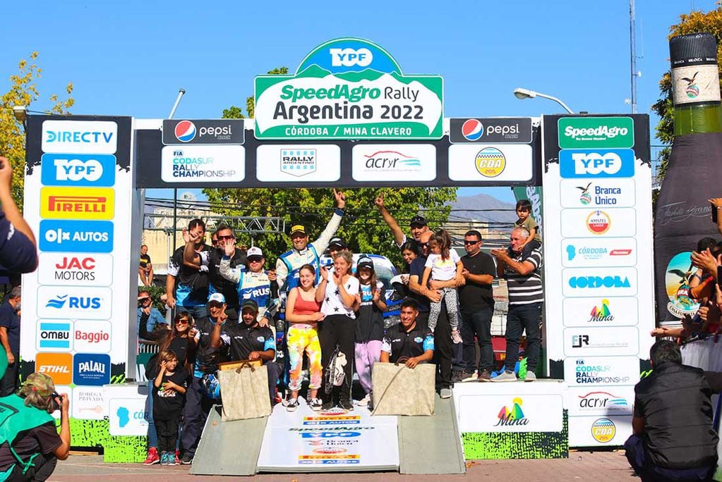 Rally Argentina 2022. Ligato y su navegante García celebran la victoria junto a su equipo, Tango Rally Team, y familiares en el podio del evento, en Mina Clavero.