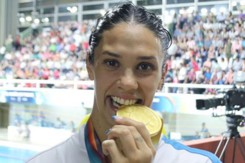 Macarena Ceballos chequea que su medalla de los 100 metros pecho sea de oro. La riocuartense piensa ganar muchas más en Asunción. (Prensa COA)