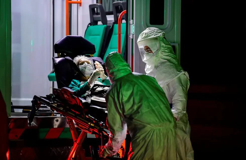 TOPSHOT - Health care workers in protective gear arrive to transport elderly patients, allegedly infected with the new COVID-19 coronavirus, from a nursing home to an ambulance of the Emergency Medical Care Service (SAME) in the Belgrano neighbourhood of Buenos Aires, Argentina, on April 21, 2020. (Photo by RONALDO SCHEMIDT / AFP)