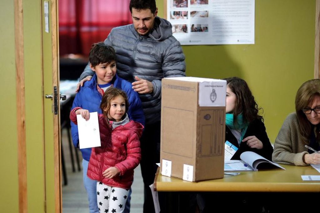 Imagen archivo. Un padre y sus dos hijos votaron en las primarias de agosto que reportó un gasto de 770 millones en total y que suministró el Estado. Foto: EFE/Juan Ignacio Roncoroni.
