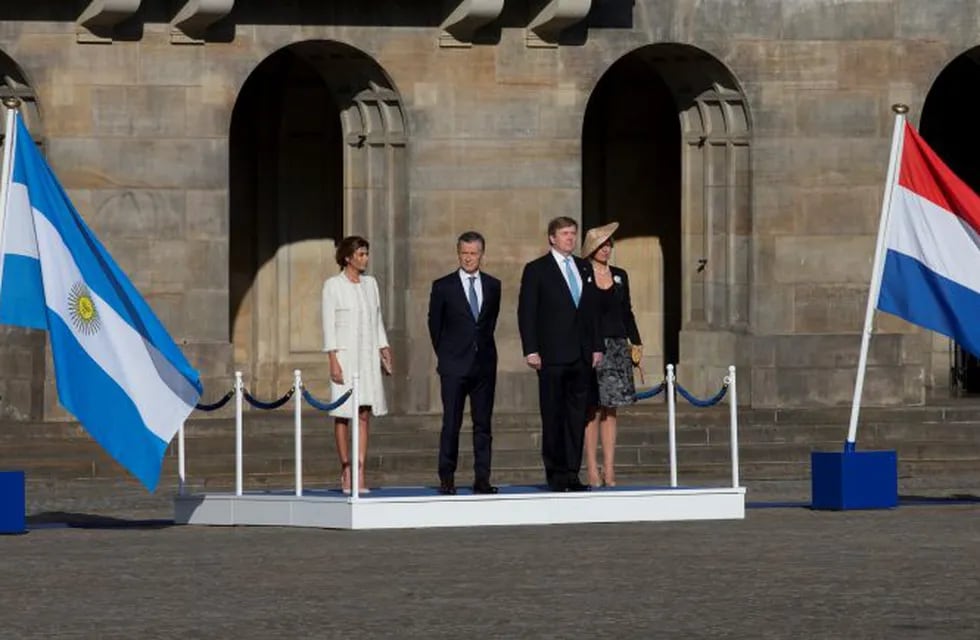 Argentina's President Mauricio Macri, center left, his wife Juliana Awada, left, Dutch King Willem Alexander , second right, and his wife Queen Maxima, listen to the national anthems after their arrival at the royal palace in Amsterdam, Netherlands, Monda