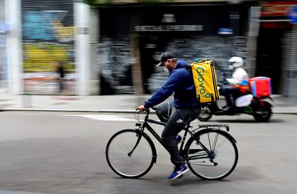 A cyclist working for the food delivery service Glovo rides in Madrid on April 30, 2020 during a national lockdown to prevent the spread of the COVID-19 disease. - Spain counted another 268 people who have died from the coronavirus, the lowest daily number since March 20 as the country prepares to ease its tough lockdown measures. (Photo by JAVIER SORIANO / AFP)