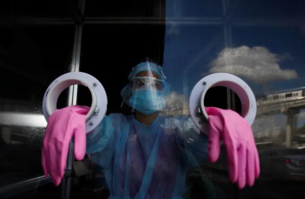 PA1001. CIUDAD DE PANAMÁ (PANAMÁ), 24/8/2020.Personal médico se prepara para realizar pruebas de hisopado para detectar coronavirus hoy en una estación express en el distrito de San Miguelito en ciudad de Panamá (Panamá). Personas formadas en una larga fila esperaban este lunes ser atendidas en un centro de \