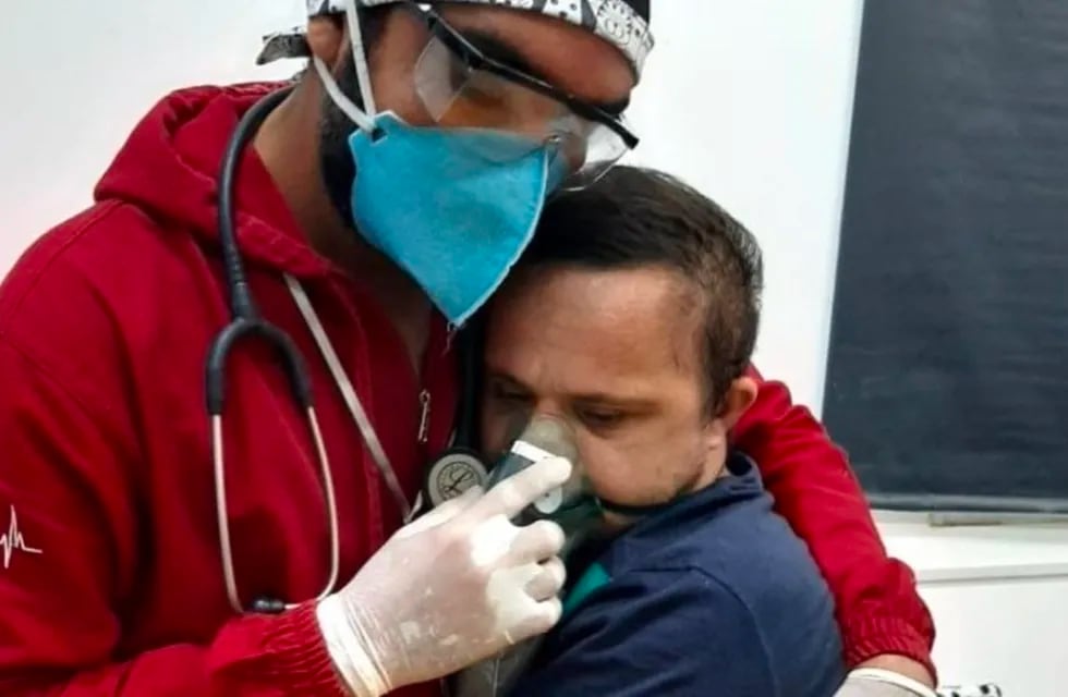 Se hace viral una foto de un enfermero que abraza a un joven con síndrome de Down infectado de Covid-19 para tranquilizarlo.