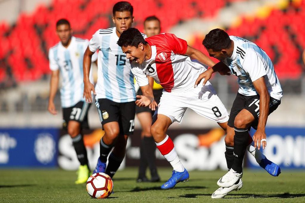 El jugador de la selección peruana de fútbol Jairo Concha,  disputa el balón con el seleccionado de Argentina Facundo Medina (d) este sábado, durante un partido del campeonato sudamericano Sub20, en el estadio Fiscal de Talca (EFE).
