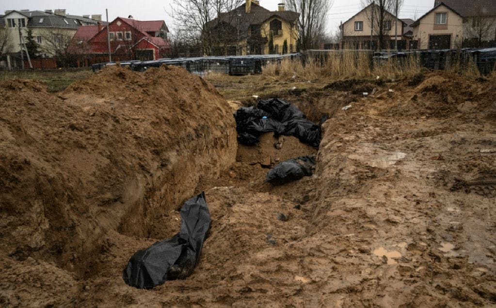Las tropas rusas enterraron cuerpos en fosas comunes, mientras dejaron en la calle otros restos de civiles.  (AP)