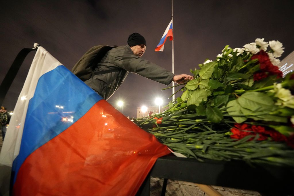 Un hombre coloca flores en un altar improvisado a las víctimas del ataque en Moscú, en San Petersburgo, Rusia, el sábado 23 de marzo de 2024.