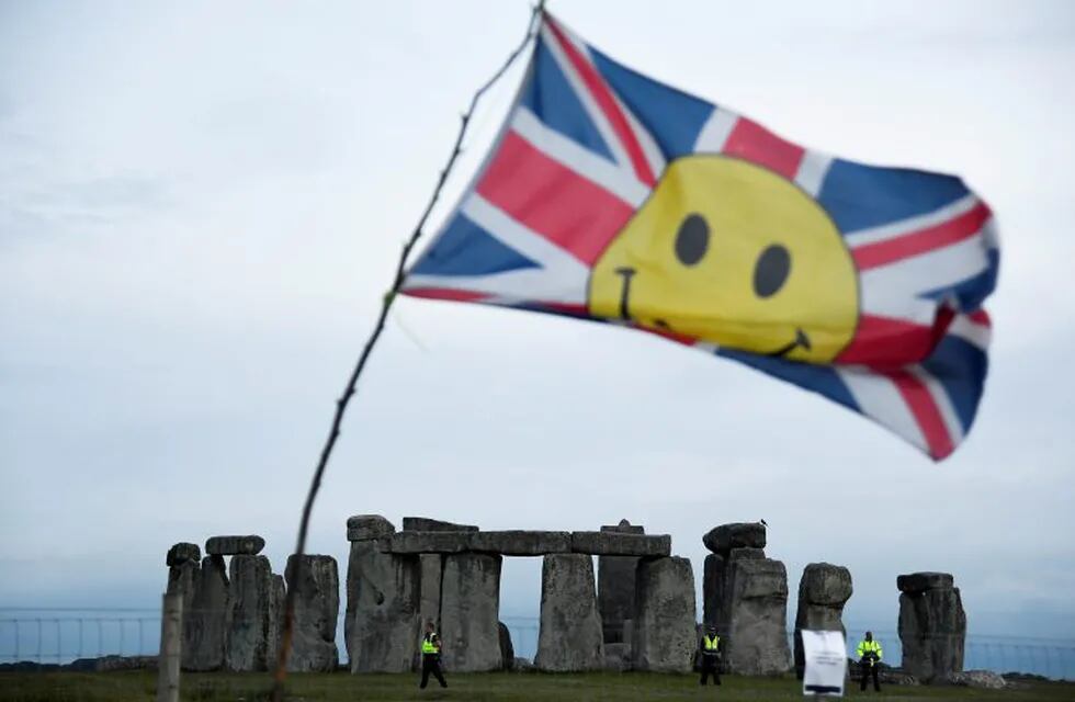 A flag flutters as security officers patrol while revellers celebrate near Stonehenge stone circle, despite official Summer Solstice celebrations being cancelled due to the spread of the coronavirus disease (COVID-19), near Amesbury, Britain June 20, 2020. REUTERS/Toby Melville     TPX IMAGES OF THE DAY