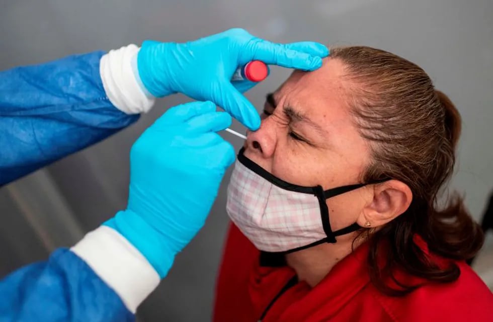 A health worker collects a swab sample from a woman to get her tested for COVID-19 in Nezahualcoyotl, Mexico state on July 13, 2020 amid the coronavirus pandemic. - Mexico became on Sunday the fourth country with the most deaths in the world from the new coronavirus after overtaking Italy, according to an AFP report based on government sources. (Photo by PEDRO PARDO / AFP)  hisopado