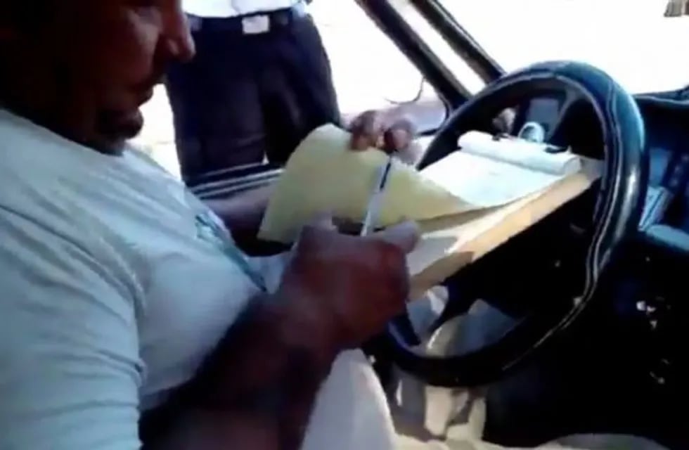El momento en que el conductor coloca el dinero que confirma la coima por parte del inspector municipal rosarino. (Captura de pantalla)
