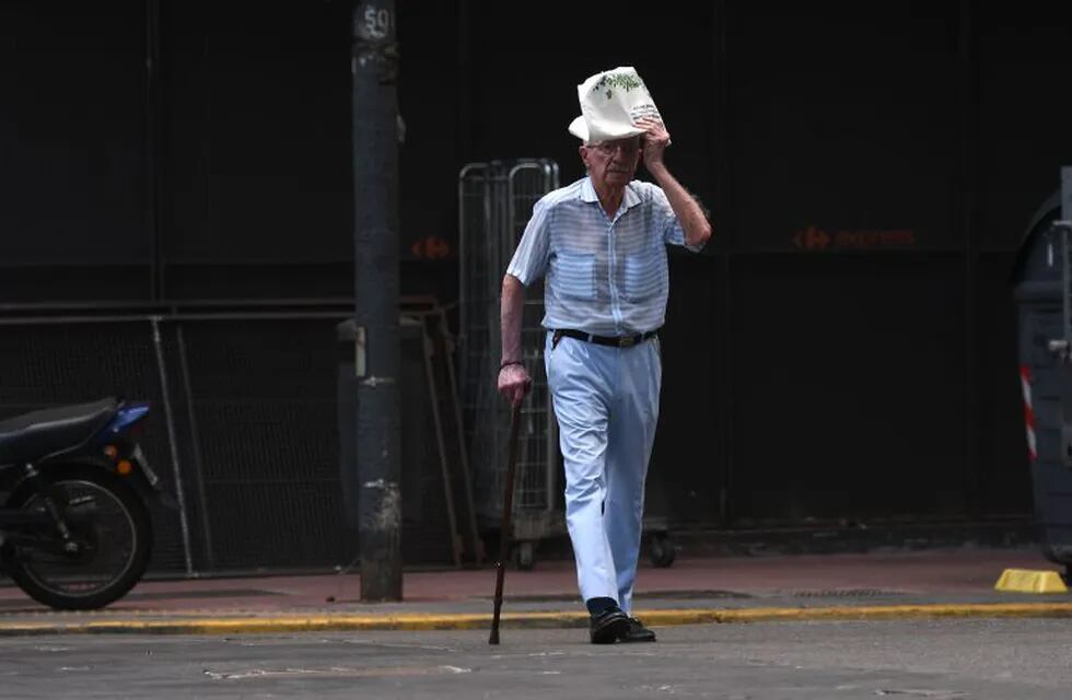 Un hombre se cubre la cabeza con un  diario en Buenos Aires.