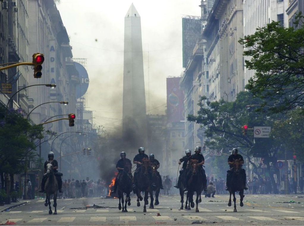 La policía montada a caballo avanza contra los manifestantes en la 9 de Julio y Diagonal Sur. A las 19.37, renunciaba el presidente.