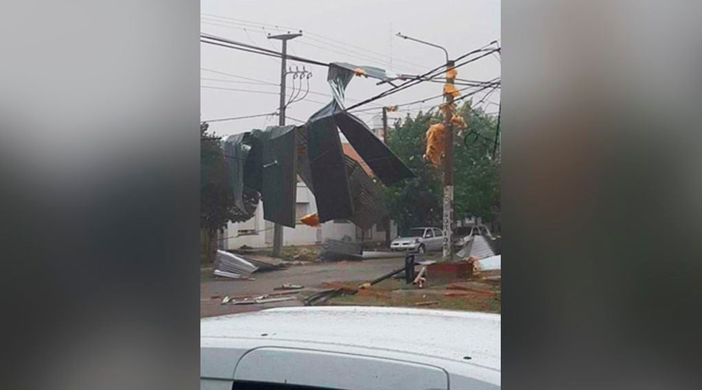 Chapas de un techo que quedaron colgando de los cables de luz 