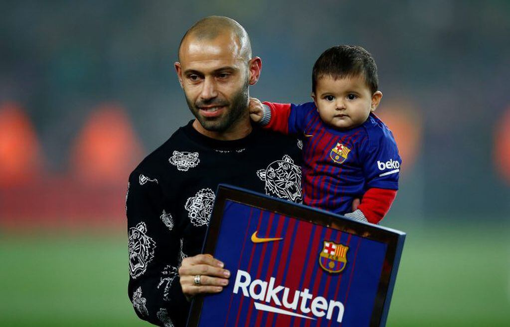 FC Barcelona's Javier Mascherano holds his son during his farewell, prior to the Spanish Copa del Rey, quarter final, second leg, soccer match between FC Barcelona and Espanyol at the Camp Nou stadium in Barcelona, Spain, Thursday, Jan. 25, 2018. Barcelona have confirmed Javier Mascherano has signed with Chinese Super League outfit Hebei China Fortune after eight years at FC Barcelona. (AP Photo/Manu Fernandez)