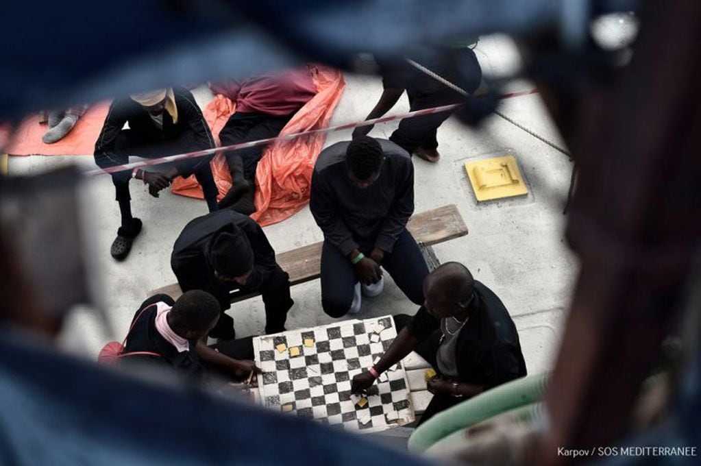 Los inmigrantes libios matan el tiempo mientras esperan llegar a España. (AFP)