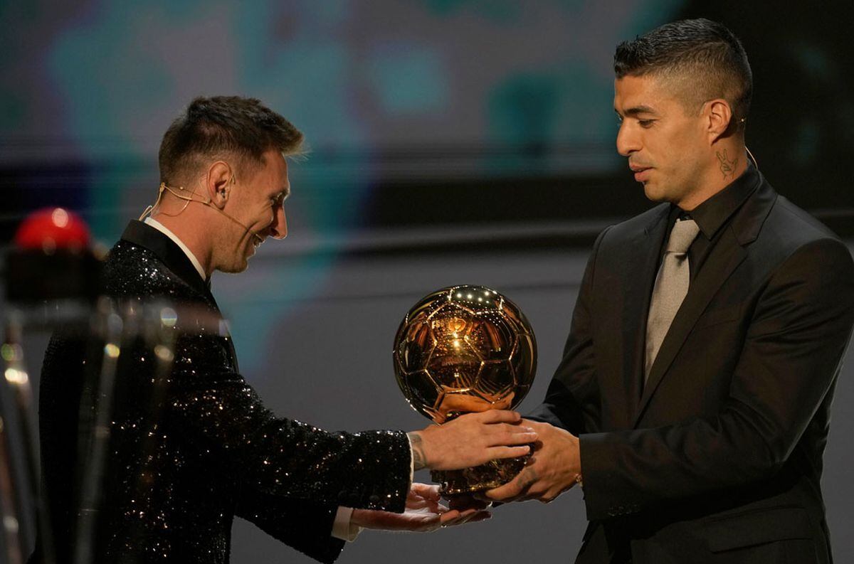 Una imagen que no se repetirá: Lionel Messi recibiendo el Balón de Oro de manos de su amigo Luis Suárez.