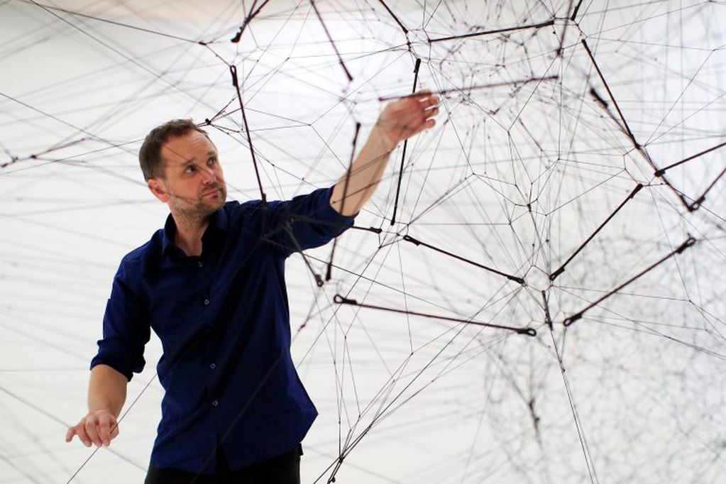 El artista Tomás Saraceno -conocido como " el Spiderman del arte"- posando dentro de su obra "Algo R (h) i (y) thms" antes de la inauguración de su exposición "On Air" en el centro de arte contemporáneo del Palacio de Tokio, en París, Francia, el 15 de octubre de 2018. (REUTERS/Gonzalo Fuentes)