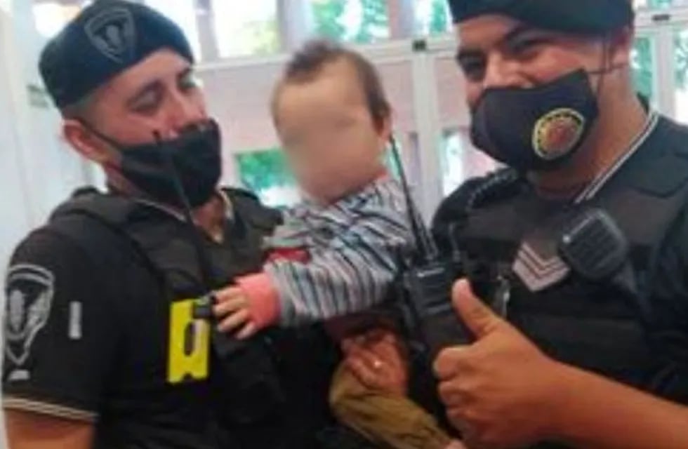 Jorge Moscardini y  Daniel Barros,  con el bebé al que salvaron, en Villa el Libertador.