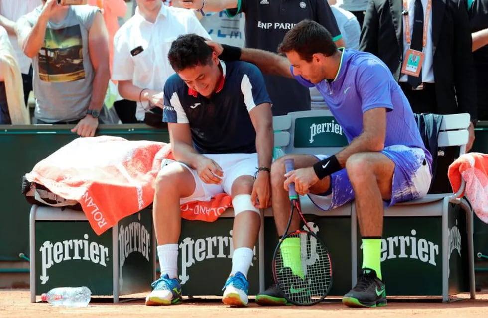 TOPSHOT - Spain's Nicolas Almagro (L) is comforted by Argentina's Juan Martin Del Potro as he has to give up due to an injury during their tennis match at the Roland Garros 2017 French Open on June 1, 2017 in Paris.  / AFP PHOTO / Thomas SAMSON