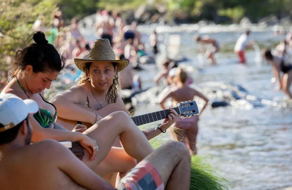 Sol y río. Con la guitarra, junto al agua, turistas disfrutan ayer en el balneario Mate de Luna, de Santa Rosa de Calamuchita (LaVoz).