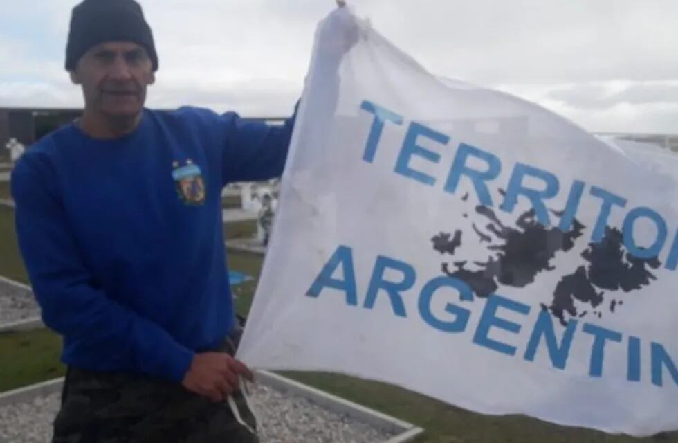 Escobedo con la bandera que lleva cada vez que va a Malvinas.