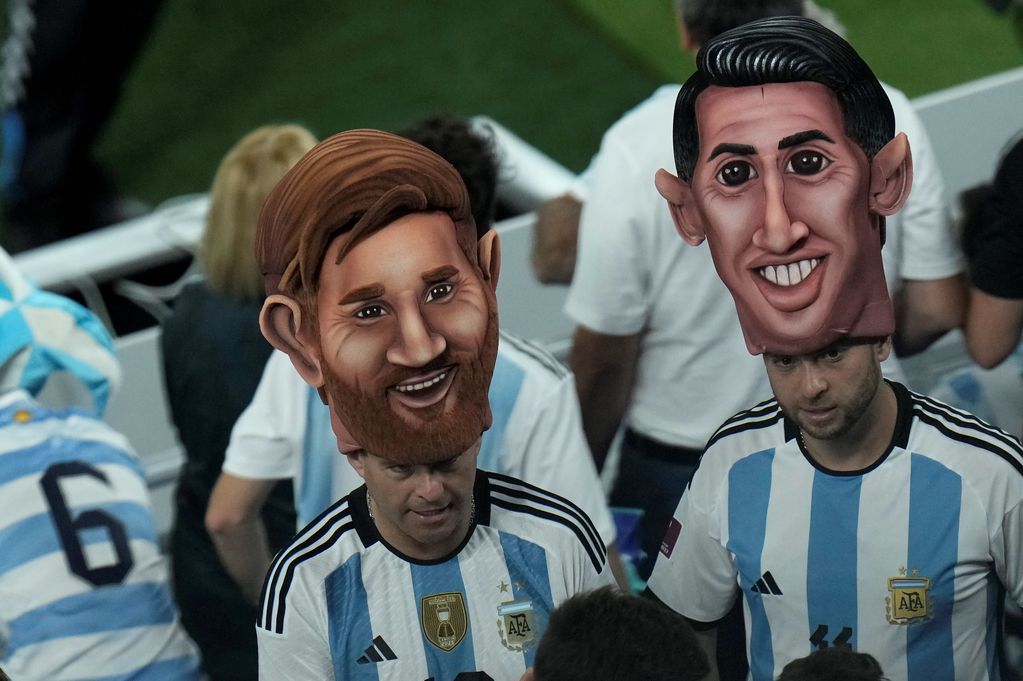 Las caretas de Lionel Messi y Ángel Di María en la tribuna del estadio 974 de Doha, Qatar, donde Argentina venció 2-0 a Polonia. (AP)