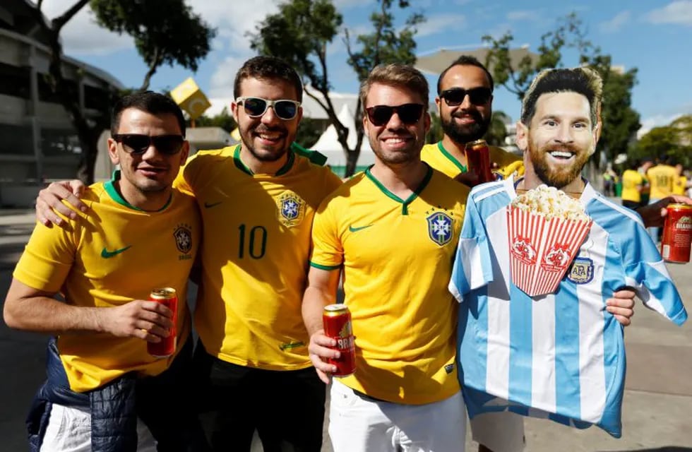 Fans of Brazil hold a life-size cardboard cut-out of Argentina's striker Lionel Messi eating popcorn and wearing an Argentina soccer jersey outside the Maracana stadium prior to the final soccer match of the Copa America between Brazil and Peru in Rio de Janeiro, Brazil, Sunday, July 7, 2019. (AP Photo/Natacha Pisarenko)