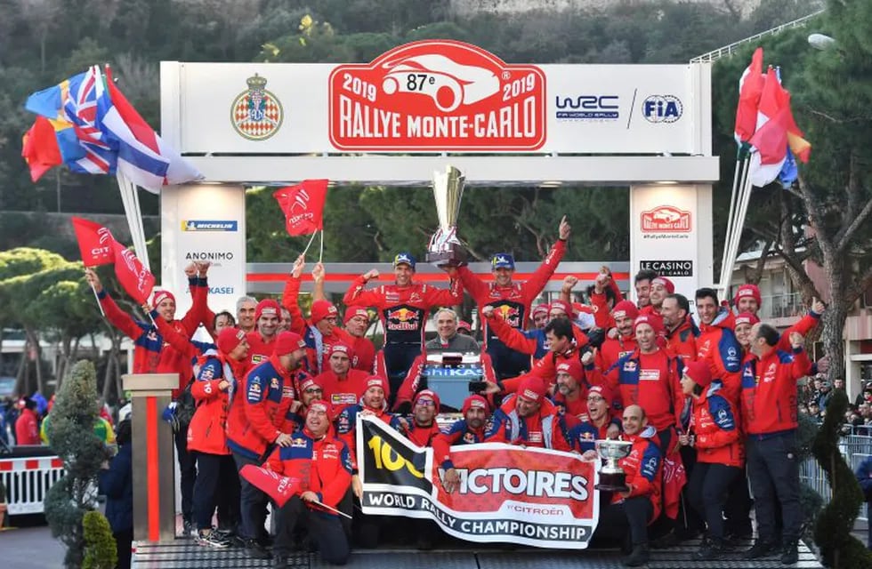 French driver Sebastien Ogier (C-R) and his co-driver Julien Ingrassia (C-L) hold the trophy as they celebrate with their team after winning the 87th Monte-Carlo Rally on January 27, 2017, in Monaco. - Reigning world champion Sebastien Ogier won the season-opening Monte Carlo Rally for a sixth straight year on. (Photo by YANN COATSALIOU / AFP)