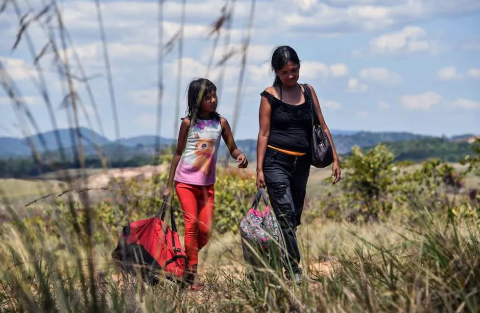 A Venezuelan woman and a girl are pictured in Pacaraima, Roraima state, Brazil shortly after crossing the Venezuela-Brazil border on February 26, 2019. (Photo by NELSON ALMEIDA / AFP)