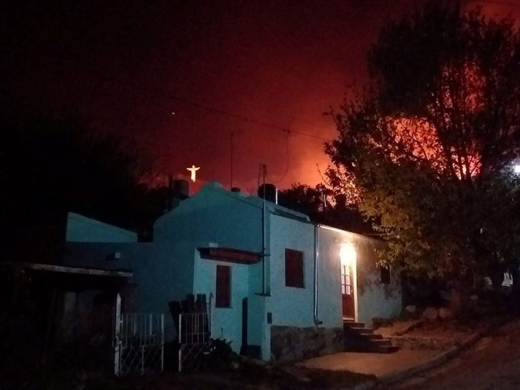 Cristo Redentor de La Cumbre iluminado por las llamas.