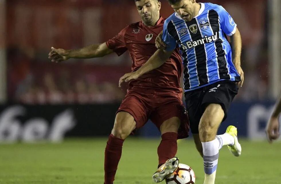 Brazil's Gremio defender Walter Kannemann (R) vies for the ball with Argentina's Independiente forward Emmanuel Gigliotti during their Recopa Sudamericana 2018 first leg final football match at Libertadores de America stadium in Avellaneda, Buenos Aires, on February 14, 2018. / AFP PHOTO / Juan MABROMATA