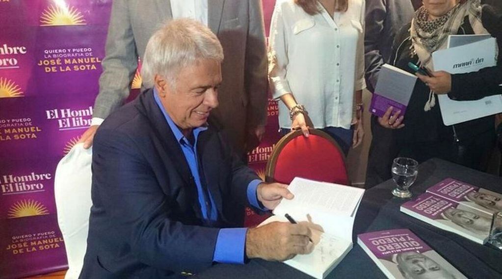 José Manuel de la Sota firmando una edición de su autobiografía, "Quiero y puedo".