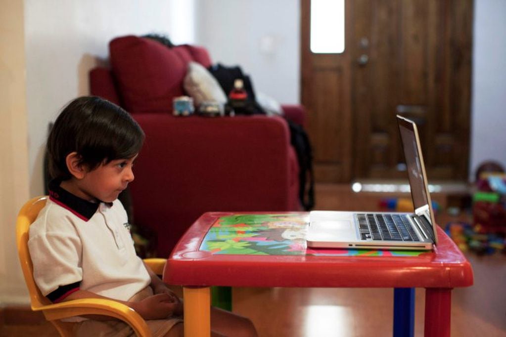 A preschool child Fabio Armendariz takes an online class at his house, in Monterrey, state of Nuevo Leon, Mexico, on August 24, 2020. - Some 30 million Mexican students began a new school year on Monday with classes broadcast on television due to the new coronavirus pandemic. (Photo by Julio Cesar AGUILAR / AFP) escuela primaria clases por zoom escuela clases on line  clases internet primaria alumno computadora  educacion a distancia  chicos laptop