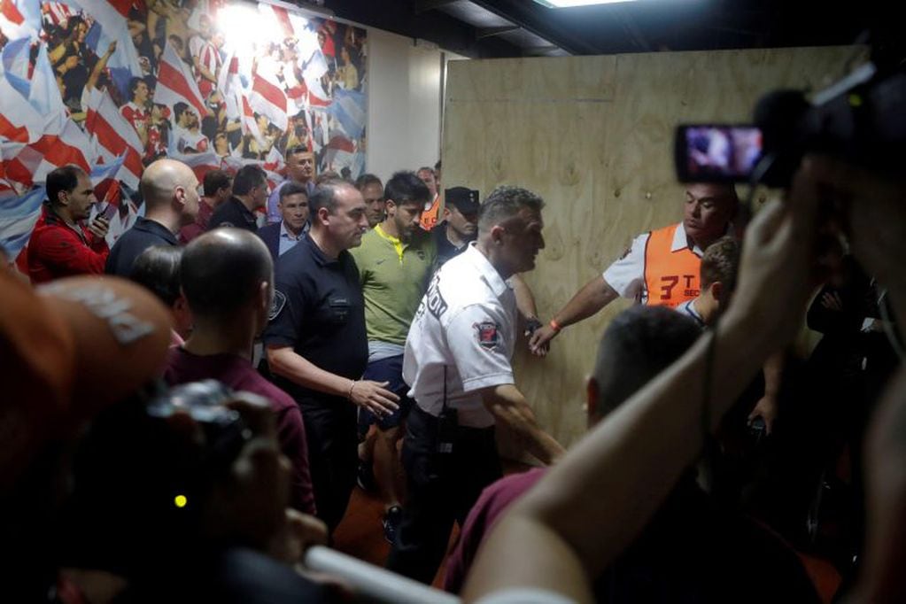 Pablo Pérez es acompañado por personal médico y policial después de los ataques de los hinchas de River (EFE)