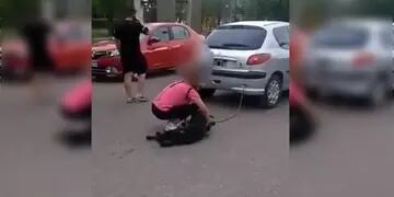 Una mujer arrastró su perro por el asfalto.