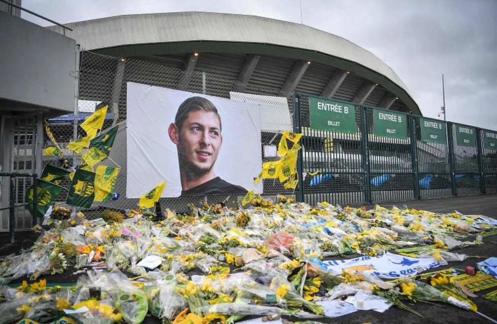 In this file photo taken on February 08, 2019 yellow flowers are displayed in front of the portrait of Argentinian forward Emiliano Sala at the Beaujoire stadium in Nantes, France. - Argentine footballer Emiliano Sala's body is to be returned to Argentina on Friday for his wake at the Club Atletico y Social San Martin in his hometown Progreso, Santa Fe province. Sala's body was recovered from plane wreckage in the English Channel last week. He was flying to his new team, English Premier League side Cardiff City, from his old French club Nantes when his plane went missing over the Channel on January 21. (Photo by LOIC VENANCE / AFP) nantes francia Emiliano sala desaparicion futbolista del nantes cuando volaba en avioneta sobre el canal de la mancha accidente aereo caida cayo avioneta homenaje al futbolista argentino fallecido en el accidente