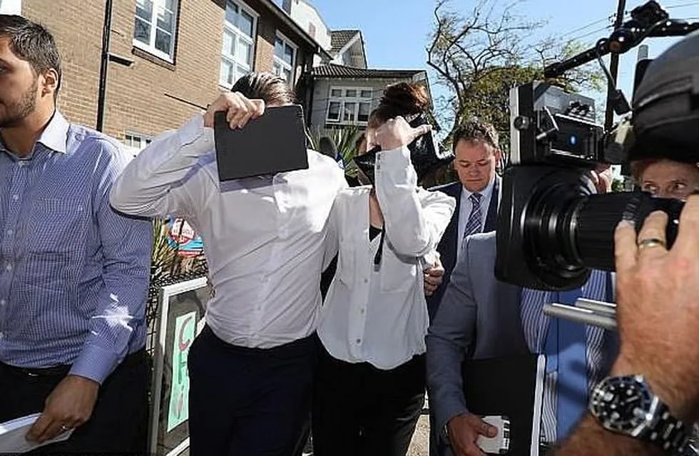 Los padres acusados de mal nutrir a su hija se tapan la cara ante las cámaras. Foto: Daily Mail Australia