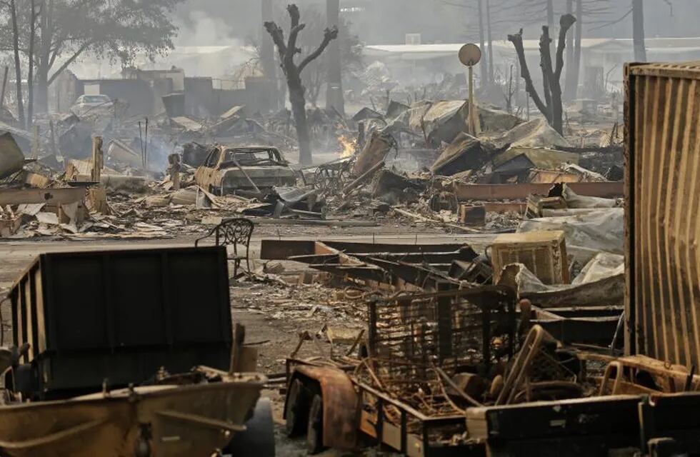 Cars sit among the debris at the Journey's End mobile home park on Monday, Oct. 9, 2017, in Santa Rosa, Calif. Wildfires whipped by powerful winds swept through Northern California early Monday, sending residents on a headlong flight to safety through smoke and flames as homes burned. (AP Photo/Ben Margot)